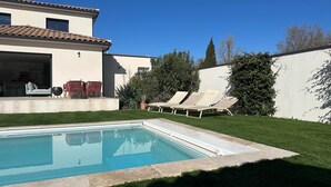 A swimming pool with lounge chairs, a patio with seating, and a well-maintained lawn. - Casa Del Sol - Quiet with heated pool (Arles)