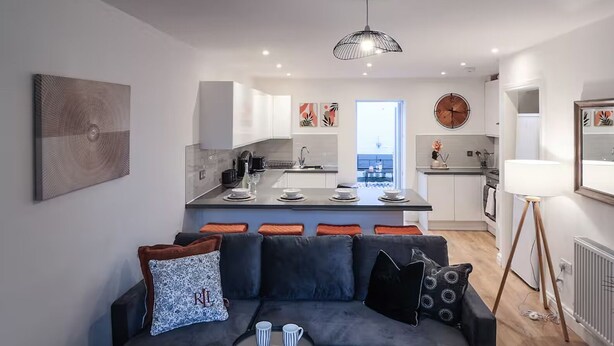 Un appartement moderne comprenant un salon, une cuisine et un coin repas.