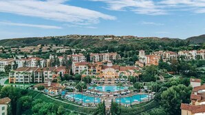 Un resort con diverse piscine, un cortile centrale e ville circostanti.
