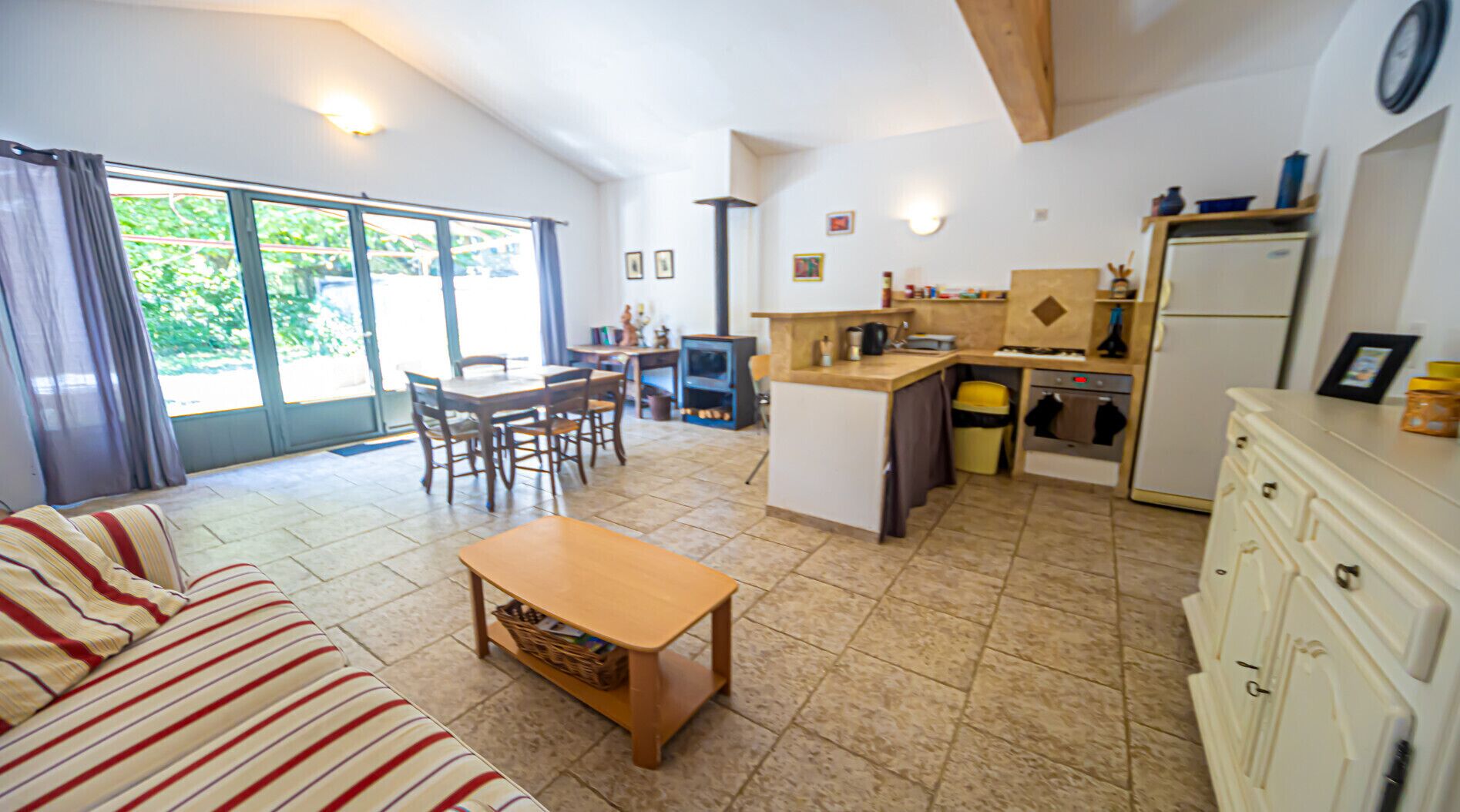 Ein Wohnzimmer mit einer Couch, einem Holztisch und einem Essbereich mit Stühlen und Tisch.
