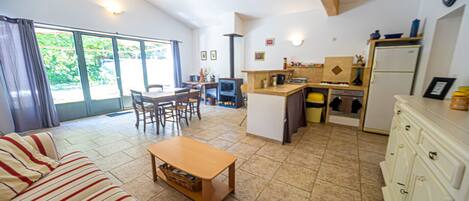 Ein Wohnzimmer mit einer Couch, einem Holztisch und einem Essbereich mit Stühlen und Tisch.