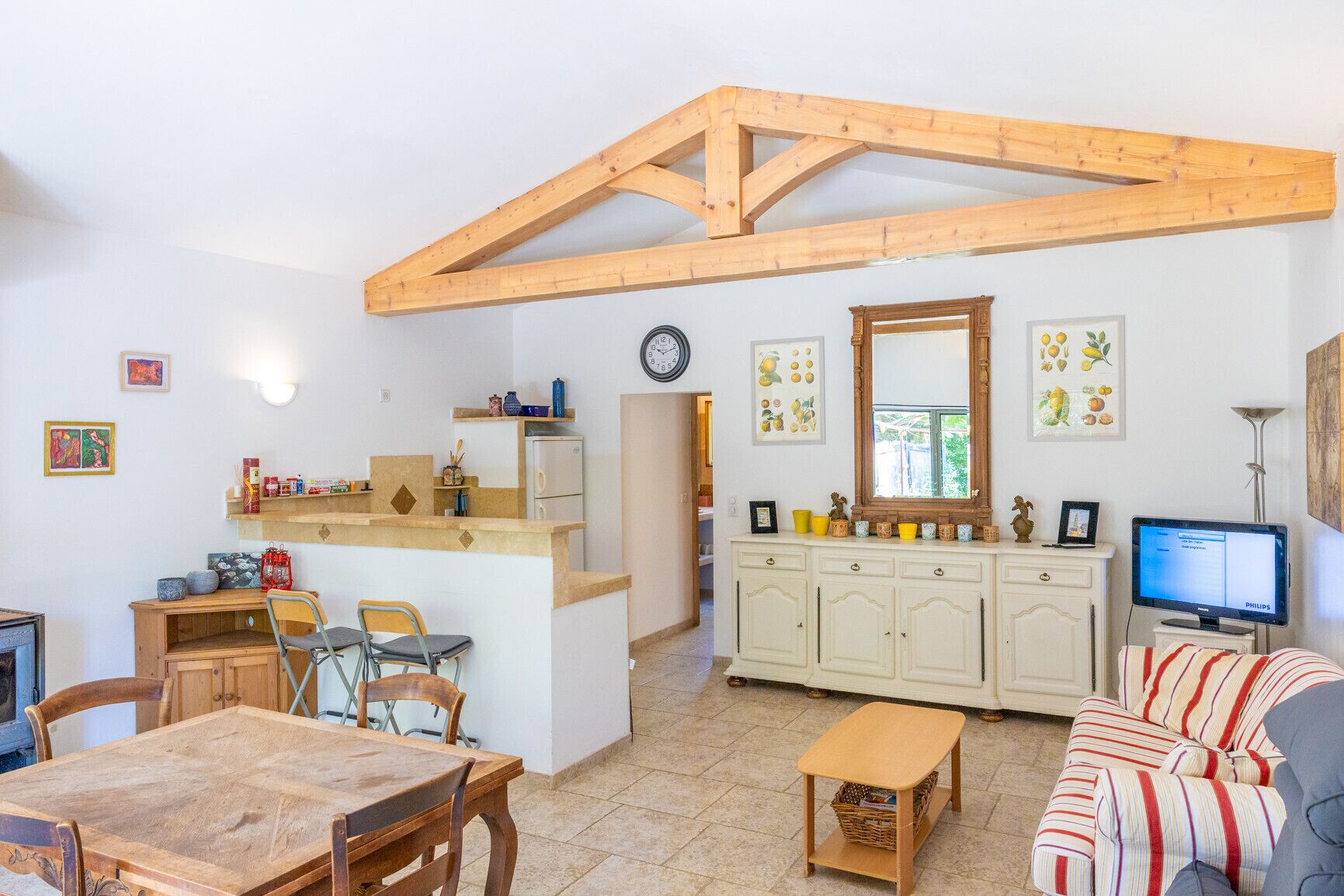A compact living space with a kitchen, dining area, and a sofa.