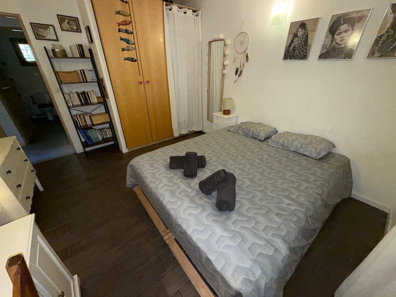 Een slaapkamer met een bed, een garderobe, een nachtkastje en een bedtafel.