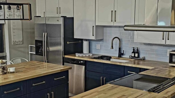 Una cucina moderna con isola centrale, elettrodomestici in acciaio inossidabile e mobili scuri.