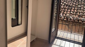 A room with a sliding door leading to a balcony with a tiled floor and a view of a tiled roof. - Romantic Apartment in an Italian Village near Pollino National Park (Castelluccio Superiore)