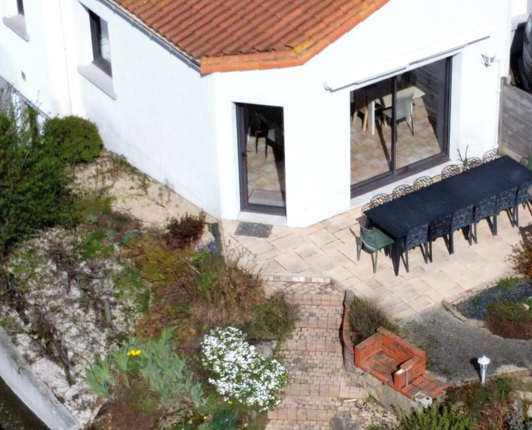A corner building with a patio, outdoor seating, and a garden area.