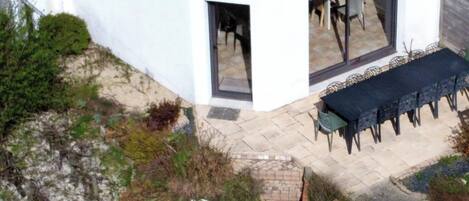 A corner building with a patio, outdoor seating, and a garden area.
