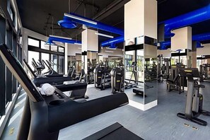 A gym with treadmills, weight machines, and exercise equipment.
