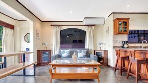 Ein modernes Wohnzimmer mit Sofa, Couchtisch und Barhocker.