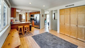 A modern kitchen with wooden cabinets, a stainless steel refrigerator, and a bar area with stools. - 18-Acre Working Farm w/ Mtn Views! Dolores Escape (Dolores)