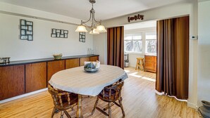 A dining area with a round table, wooden chairs, a chandelier, and a kitchen counter. - 18-Acre Working Farm w/ Mtn Views! Dolores Escape (Dolores)