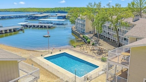 A hotel with a swimming pool, waterfront view, and docked boats. - Ozark Get-Away Lakefront Condo with Boat Slip (Osage Beach)
