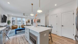 Eine moderne Küche mit Kochinsel, integriertem Backofen und einem Essbereich mit Sofa und Stühlen.