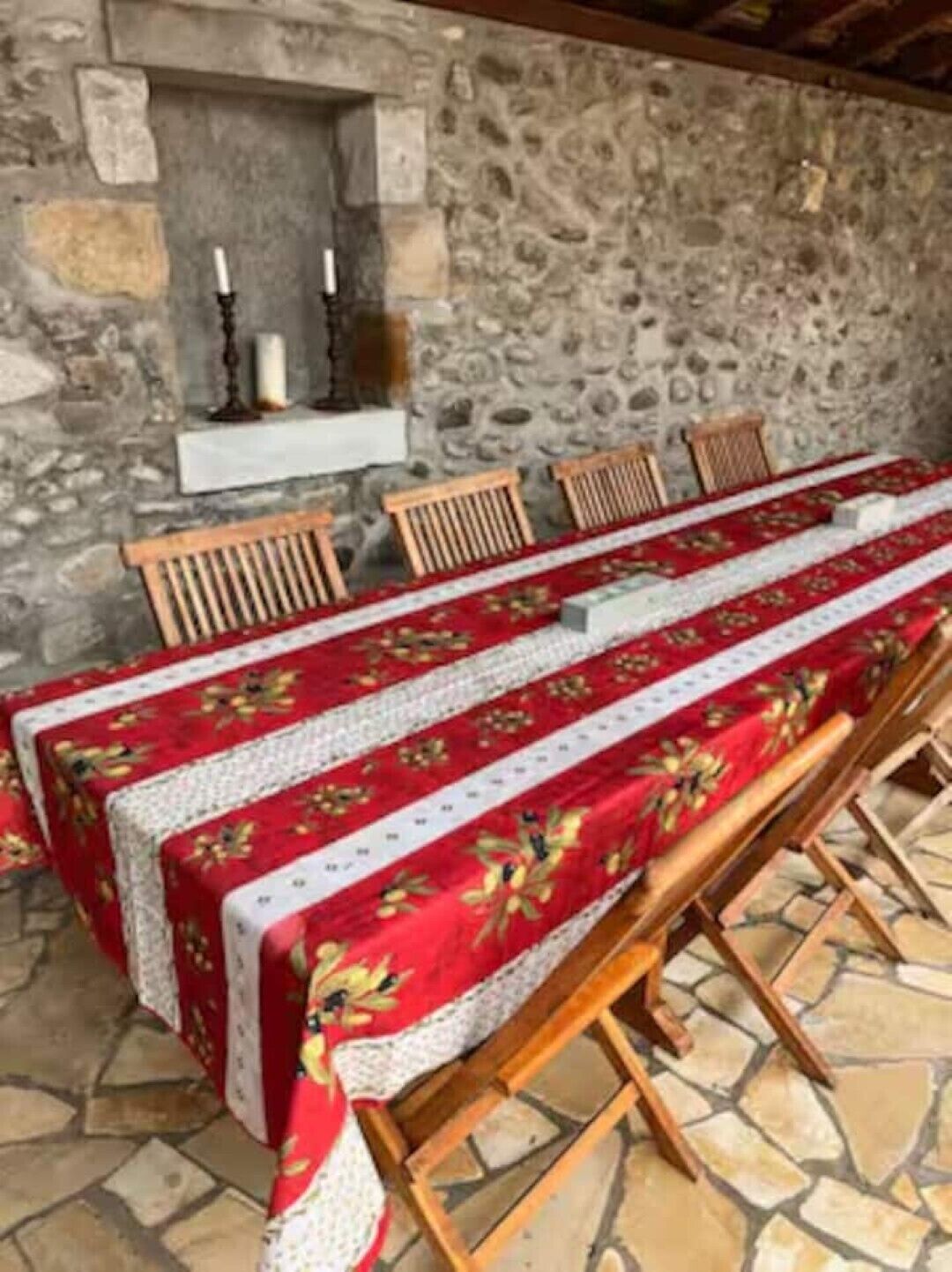 A stone wall, a fireplace, and a long dining table with chairs.