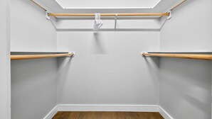 Ein Kleiderschrank mit Holzstangen und einer Kleiderstange.
