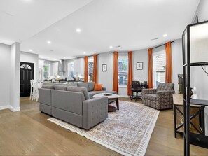 A modern living room with a grey sofa, a coffee table, and a patterned rug. - NEW! LUX 3BR w/ 400 Mbps Wifi | ROKU TV & Games! (Boston)