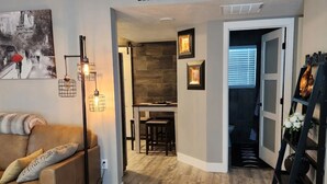Una sala de estar con sofá, mesa de centro, chimenea y un letrero en la pared que dice 'HOME SWEET HOME'.