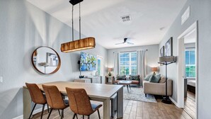 Uma cozinha moderna com mesa de jantar, cadeiras e luminária pendente.