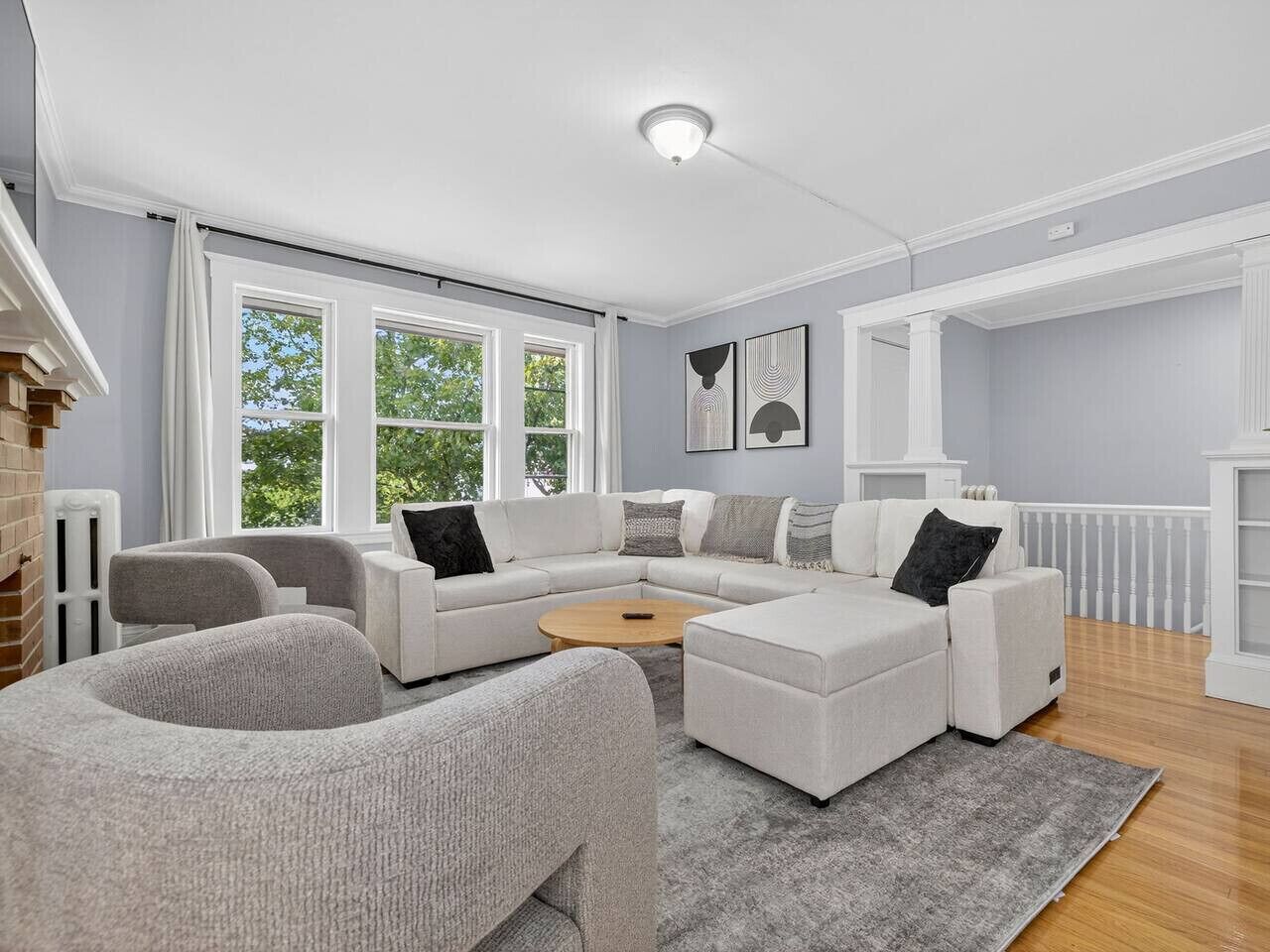 Una sala de estar moderna con un sofá modular, una mesa de centro redonda y una alfombra gris.