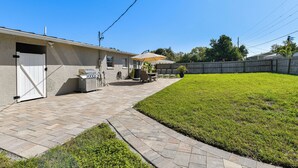 A backyard with a barbecue grill, patio furniture, and a wooden fence. - 5 Mi to Riverwalk: Bradenton Family Home w/ Yard (Bradenton)