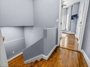 A hallway with a wooden floor, grey walls, and a door at the end. - Historic 2 floor Apt in Boston w/ outdoor deck! (Boston)