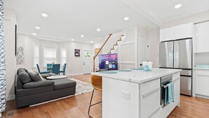 Un appartement moderne comprenant un salon, une cuisine et un escalier menant à l’étage supérieur.