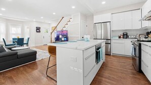 Un appartement moderne comprenant un salon, un coin repas, une cuisine et un escalier.