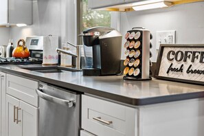 A modern kitchen with stainless steel appliances, a coffee machine, and a sign that reads "COFFEE fresh brew". - Spacious Fort Hill 3BR | Sleeps 10 (Boston)