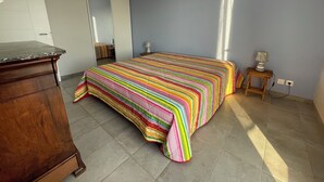 Une chambre à coucher avec un lit, une commode, un miroir et une lampe.