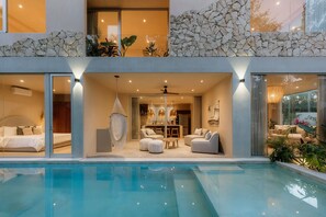 A modern house with a swimming pool, a dining area, and a bedroom with a large bed. - Villa Ka'an Pura Selva: Luxury and Nature Near the Beach (Tulum)
