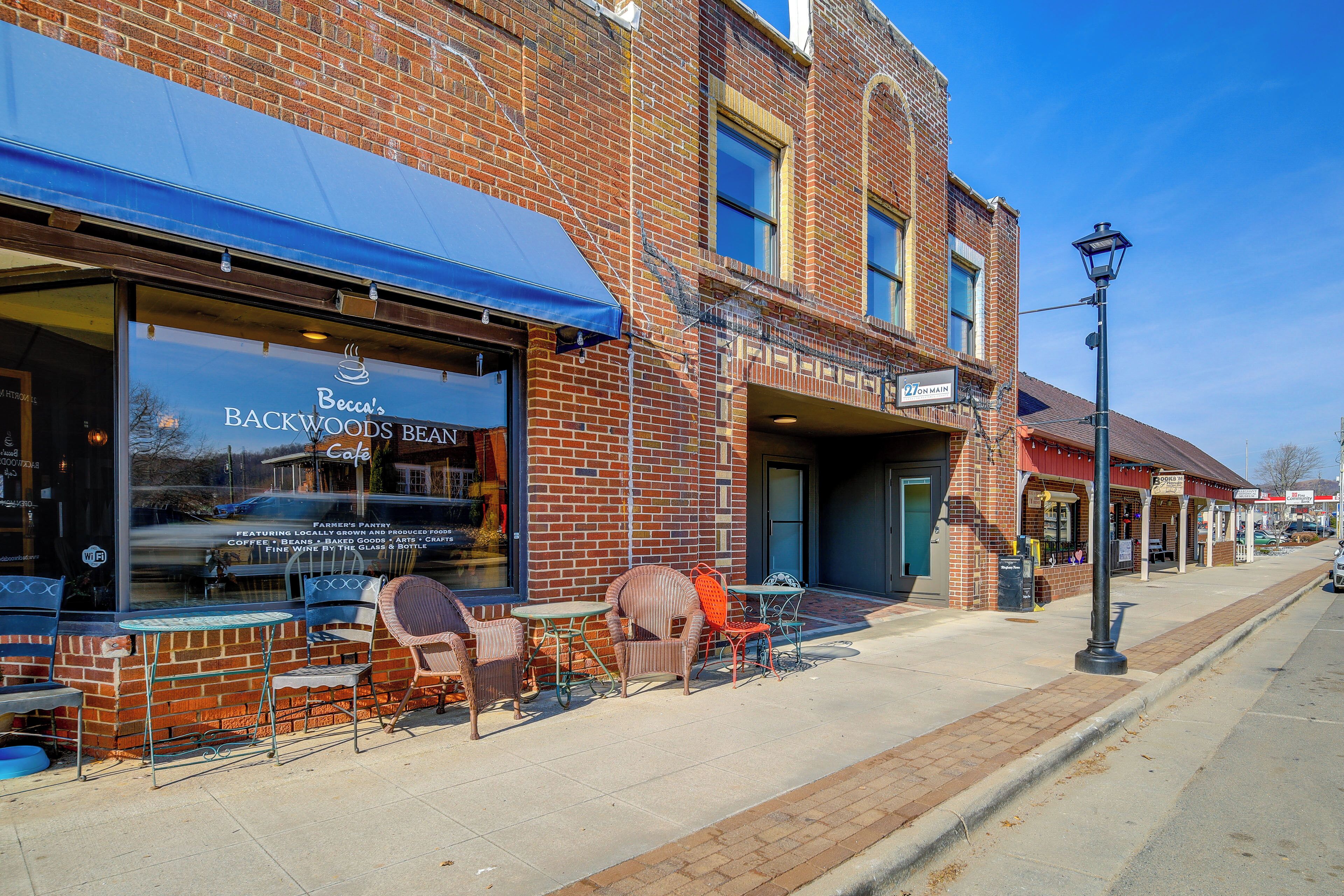 Un bâtiment en briques abritant un commerce de détail portant l’enseigne « Becca’s Backwoods Bean », qui propose un marché de producteurs, du café, des grains de café, des produits de boulangerie et des vins fins.