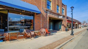 Un bâtiment en briques abritant un commerce de détail portant l’enseigne « Becca’s Backwoods Bean », qui propose un marché de producteurs, du café, des grains de café, des produits de boulangerie et des vins fins.