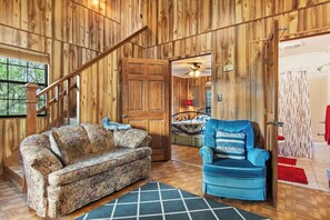 A wooden interior with a sofa, armchair, and a staircase. - Cherry Creek Cabin | Near Garner | Frio | Concan (Concan)