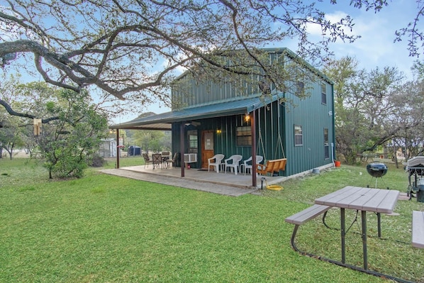 A rustic cabin with a covered patio, outdoor seating, and a barbecue area. - Cherry Creek Cabin | Near Garner | Frio | Concan (Concan)