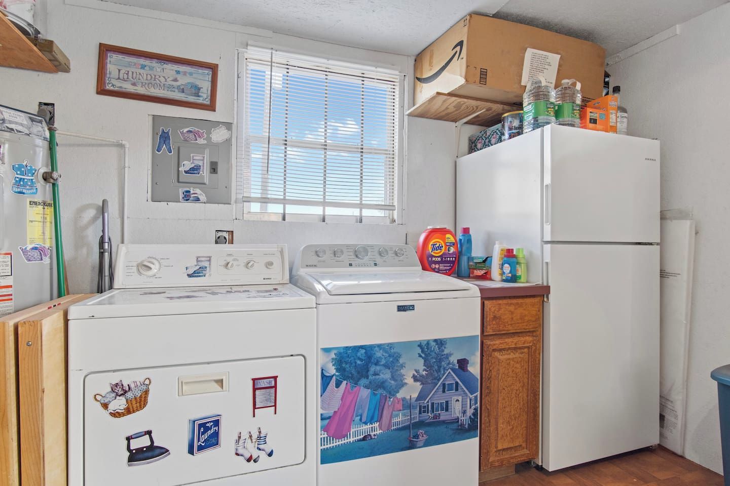 A laundry room with a washing machine, dryer, and a refrigerator.