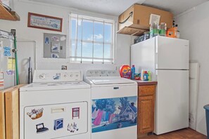 Une buanderie équipée d’un lave-linge, d’un sèche-linge et d’un réfrigérateur.