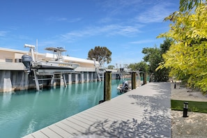 A dock with a boat, a wooden walkway, and a clear blue sky. - Manatee Cove #boatdock, #pool, #TikiHut #All Inclusive (Marathon)