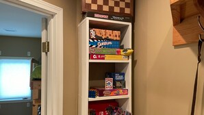 A shelf with various board games and a Nintendo Switch console. - Walk To Skiing, Quiet Neighborhood, Big House (Steamboat Springs)