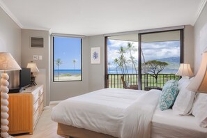 A bedroom with a bed, a dresser, a TV, and a view of the beach. - 🌅 Maui Magic! Panoramic Beachfront Stay! Ocean Views, Pool, Hot Tub, Sleeps 8🌊 (Kihei)