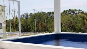 A pool with steps leading up to it, surrounded by a white structure and greenery in the background. - Rooftop small pool | El Segundo (Puerto Morelos)
