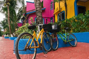 A bicycle parked next to a colorful building with a blue base and a red brick pathway. - Rooftop small pool | 5 minutes access beach (Puerto Morelos)