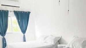 A room with two beds, a ceiling fan, and a window with curtains. - Rooftop small pool | El Segundo (Puerto Morelos)