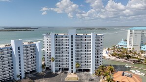 A high-rise hotel with multiple balconies, a marina with boats, and a view of the sea. - Gorgeous Punta Rassa Condo 504 - River and Sunset views! (Fort Myers)