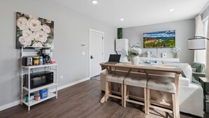 A modern kitchen with a microwave, coffee maker, and storage shelves. - Valclyde Cozy Suite-Sleeps 4-Downtown-MPLs (Minneapolis)