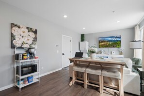 Una cocina moderna con microondas, cafetera y estantes de almacenamiento.