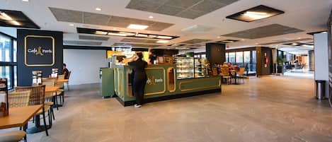 A spacious café area with a counter, seating, and a view of the outside.