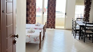Una habitación de hotel con una cama, una mesa de comedor y cortinas.