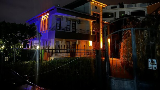 A multi-story building with balconies and a gated entrance.