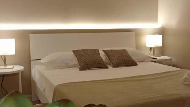 A hotel room with a bed, two bedside lamps, and a nightstand. - Narciso Boutique Apartment - room n3 (Acireale)