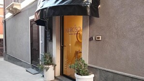 A boutique apartment with a glass door, potted plants, and a black awning. - Narciso Boutique Apartment - room n3 (Acireale)